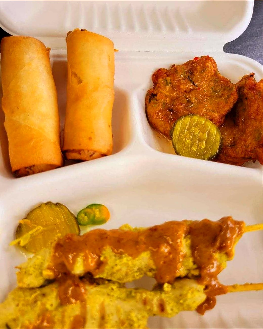 Chicken satay skewers with peanut sauce and spring rolls